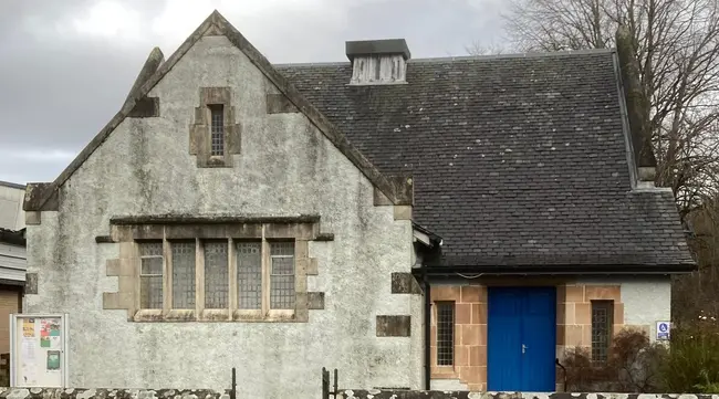 Village Hall, with small wall in front, and blue door to the right