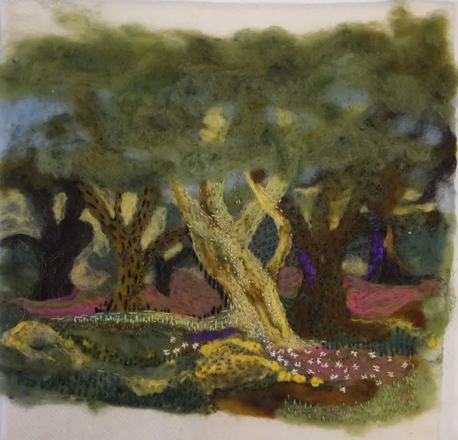 A delicately embroidered panel of trees and underbrush in muted greens and browns.